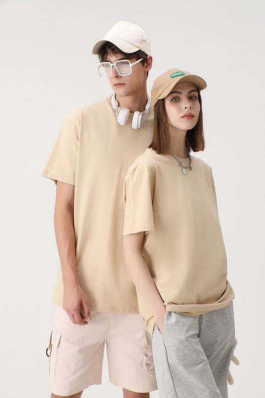 Two models showcasing beige unisex crew neck T-shirts, paired with casual accessories like hats, sunglasses, and headphones. One model is wearing beige shorts, while the other is wearing grey sweatpants.