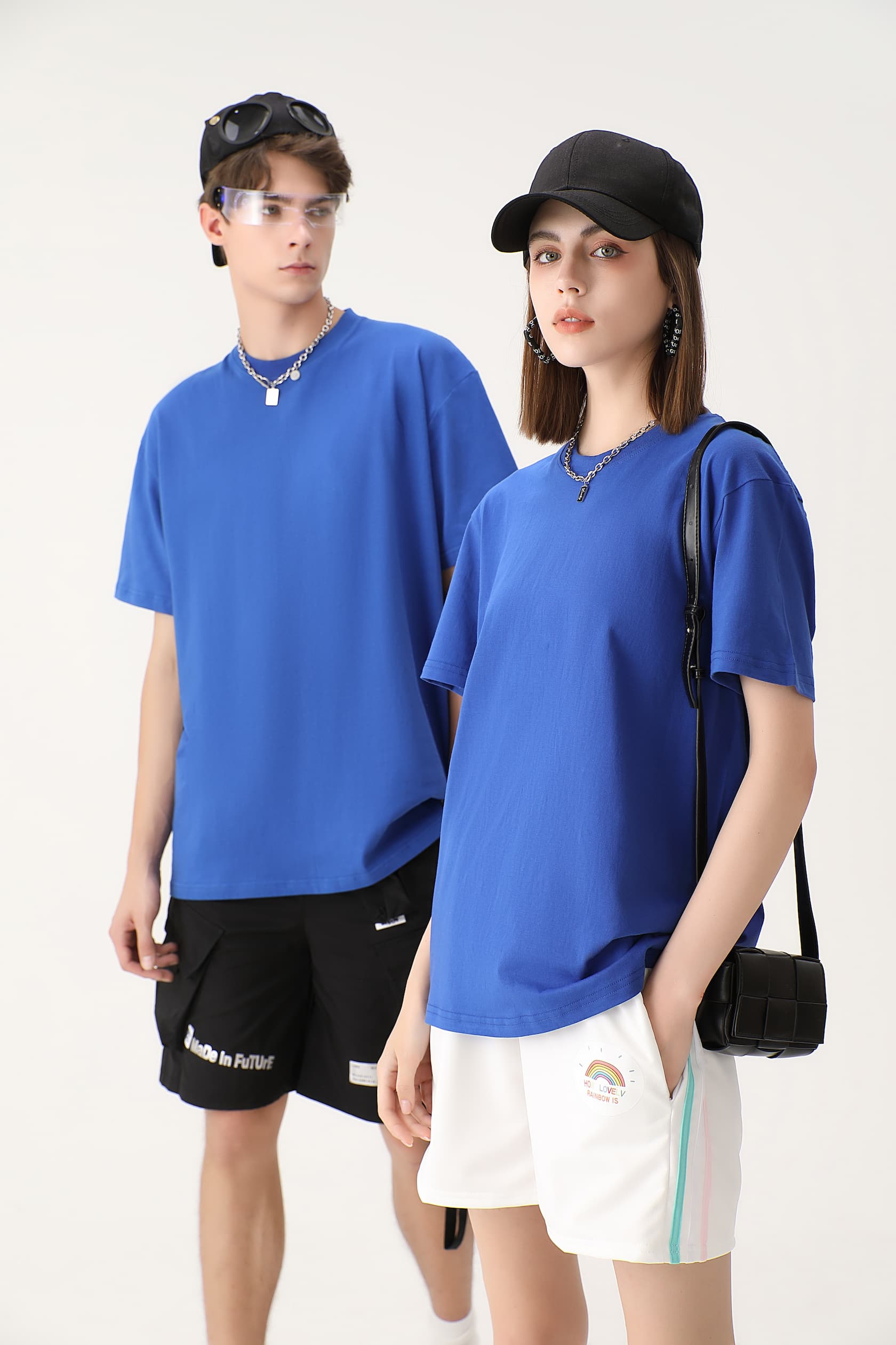 Male and female models wearing matching blue cotton crew neck T-shirts, paired with casual outfits. The minimalist design of the shirts offers a comfortable and stylish look for both men and women.